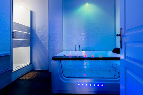 a blue bathroom with a tub and a sink at Suite and Spa 21 in Dijon