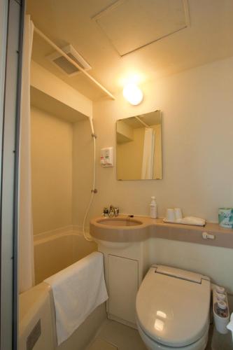 a bathroom with a toilet and a sink and a mirror at Smile Hotel Asakusa - Vacation STAY 72165v in Tokyo