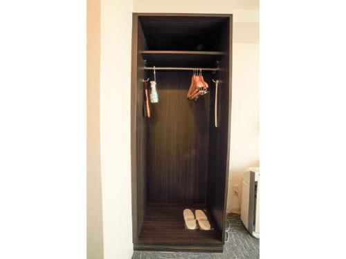 een kamer met een houten deur met paar schoenen bij Smile Hotel Asakusa - Vacation STAY 71442v in Tokyo