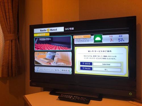 een televisie op een tafel met afstandsbediening bij Smile Hotel Asakusa - Vacation STAY 71442v in Tokyo