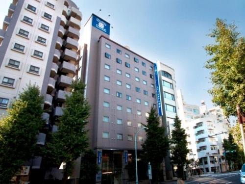 een hoog gebouw met bomen ervoor bij Smile Hotel Asakusa - Vacation STAY 71442v in Tokyo