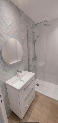 une salle de bain blanche avec un lavabo et une douche dans l'établissement Nice bas Cimiez- Coquet F1, climatisée, Parking, à Nice