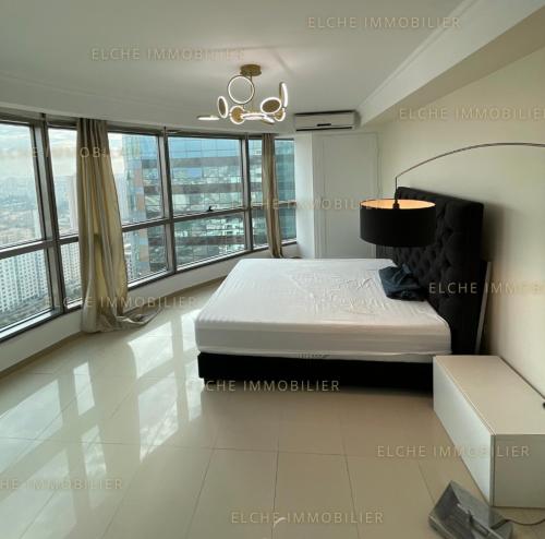 Schlafzimmer mit einem Bett und großen Fenstern in der Unterkunft Appartement mobilart in Oran