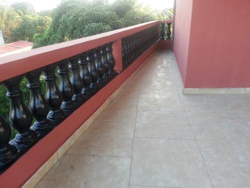 a balcony with a red railing and a sidewalk at Villa CALI Napa in Sambava