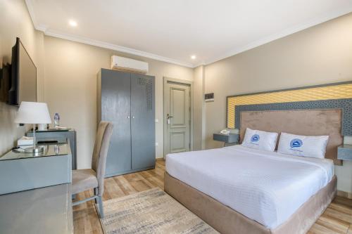 a bedroom with a bed and a desk and a chair at Mamlouk Pyramids Hotel in Cairo