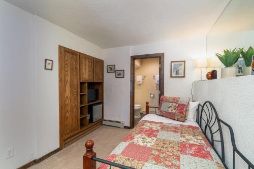 a small bedroom with a bed and a bathroom at Manitou Lodge 4 by Alpine Lodging Telluride in Telluride