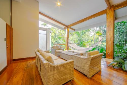 a living room with wicker chairs and a porch at Chachagua Rainforest Hotel & Hot Springs in Fortuna