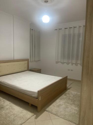 1 dormitorio con 1 cama en una habitación blanca en Mezes fushe Kashar, en Tirana