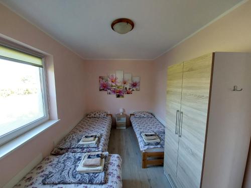 a room with two beds and a window at Domek Różany in Lubiatowo