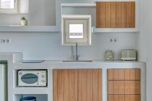 a kitchen with a sink and a microwave at Lil Paros Luxury suites in Prodromos Paros