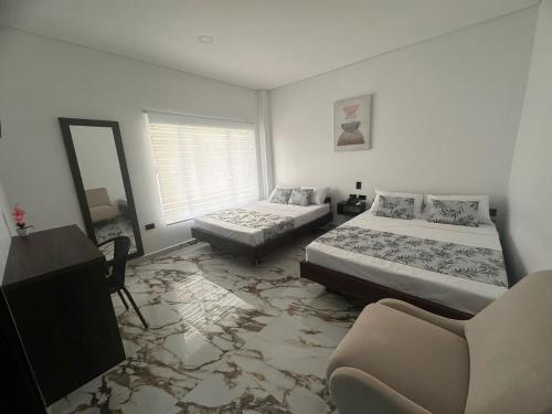 a bedroom with two beds and a mirror at ZAFIRO HOTEL in Doradal