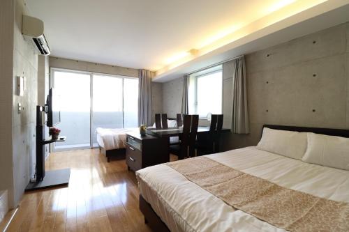 Habitación de hotel con cama, escritorio y habitación con cama en Ideal Tennoji - Vacation STAY 15959, en Osaka