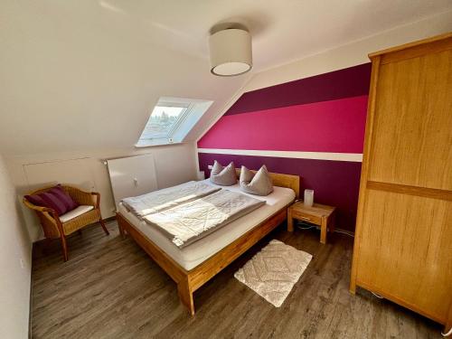 ein Schlafzimmer mit einem Bett und einer lila Wand in der Unterkunft Ferienwohnung Felderhaldeblick in Isny im Allgäu