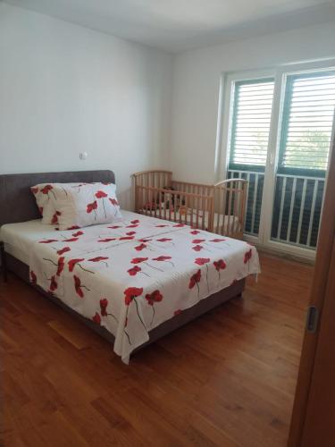 a bedroom with a bed with a white blanket with red flowers at Gabriela in Nin