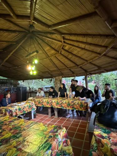 um grupo de pessoas sentadas em torno de uma longa mesa em hostal Sueño Paraiso- Observatorio astronómico em Popayán