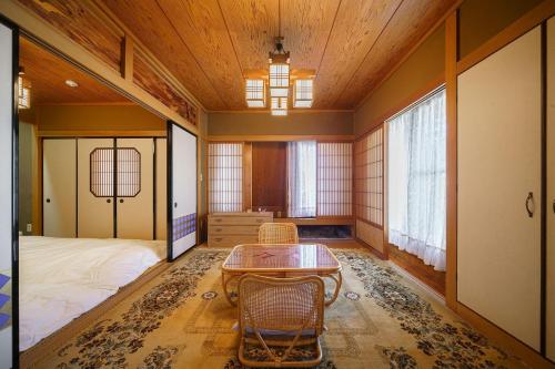 加賀市にあるOyado Tonbo - Vacation STAY 16107のベッド、テーブル、椅子が備わる客室です。