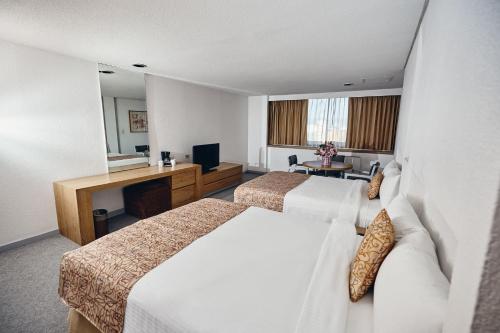 Habitación de hotel con 2 camas y escritorio en Hotel del Prado en Ciudad de México