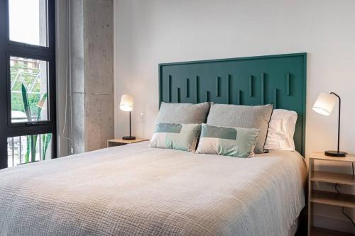 a bedroom with a large bed with a green headboard at Anida Silk 401 in Guatemala