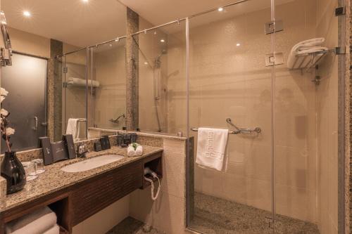 y baño con lavabo y ducha acristalada. en Stella Di Mare Grand Hotel, en Ain Sokhna