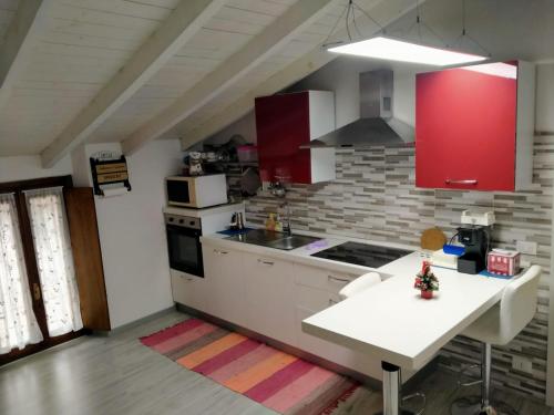 uma cozinha com armários vermelhos e um balcão branco em Appartamenti Centro Seriate em Seriate