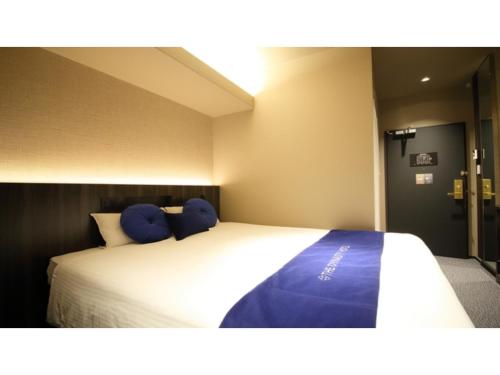 a bedroom with a large white bed with blue pillows at Dynasty Hotel Osaka - Vacation STAY 61762v in Osaka