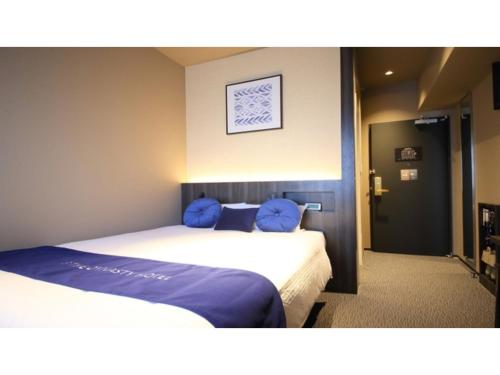 two beds in a hotel room with blue pillows at Dynasty Hotel Osaka - Vacation STAY 61689v in Osaka