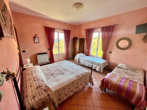 1 dormitorio con 2 camas y 2 ventanas en La Casa Rosa, en Borghetto di Vara