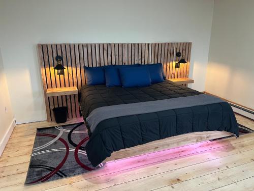 um quarto com uma cama grande e almofadas azuis em Borealis Escapes Apartment 