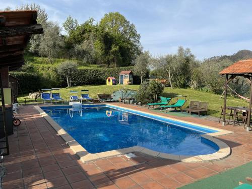 una piscina de agua azul en un patio en La Casa Rosa, en Borghetto di Vara