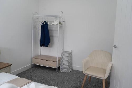 um quarto com uma cama, uma cadeira e um closet em Stylish 1 bed Apartment in Newly Refurbished Building w/ Parking & Wi-Fi em Birmingham
