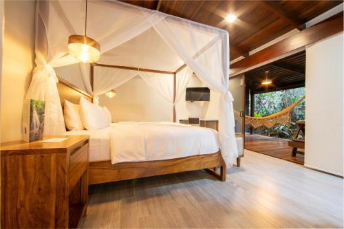 a bedroom with a canopy bed in a villa at Chachagua Rainforest Hotel & Hot Springs in Fortuna