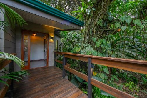 a wooden walkway leading to the front door of a house at Chachagua Rainforest Hotel & Hot Springs in Fortuna