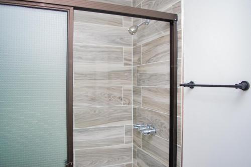 Buena Vista El Zonte في الزونت: دش مع باب زجاجي في الحمام