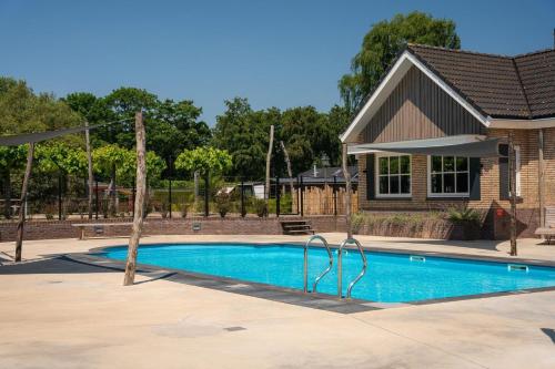 een zwembad voor een huis bij Sfeervol Boschalet 5 persoons met Sauna in Voorthuizen