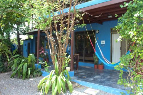 a blue house with a tree in front of it at The Blue House Panama in Chame