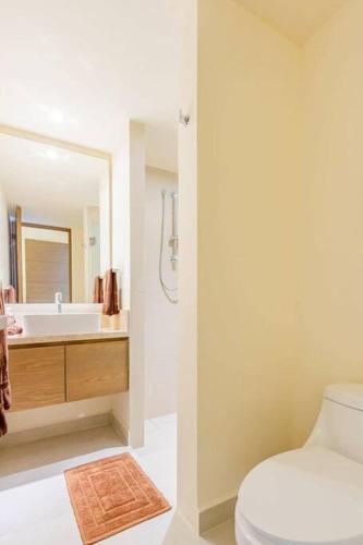 a bathroom with a toilet and a sink and a mirror at Akumal Heaven Beach Access 7 Rooftop Pools W Caribbean Sea Views + Beach Club in Akumal
