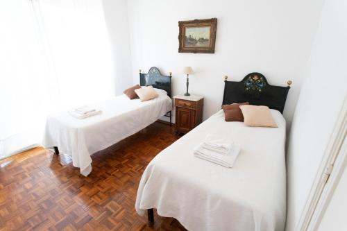 ブエノスアイレスにあるApartment in Recoletaの白い壁とウッドフロアの客室で、ベッド2台が備わります。