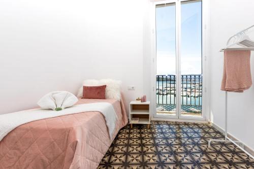 a bedroom with a bed and a balcony at EDIFICI ROSA - Exclusivo apartamento en primera línea in Port de la Selva