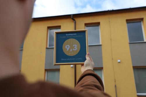 a person holding up a frame with a clock at Kolík Apartmány in Bohumín
