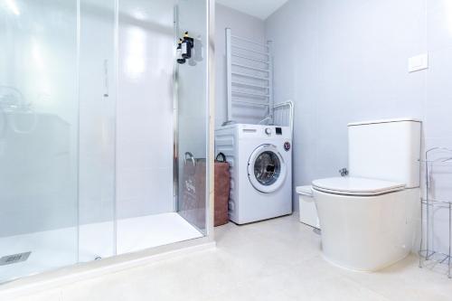 a bathroom with a washing machine and a shower at AlohaMundi San Esteban III in Seville