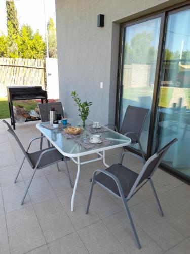 a glass table and chairs on a patio at Olivos Luján in Ciudad Lujan de Cuyo