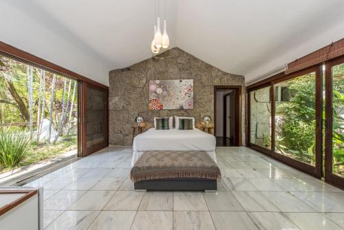 um quarto com uma cama e janelas grandes em Les Jardins de Rio Boutique Hotel no Rio de Janeiro