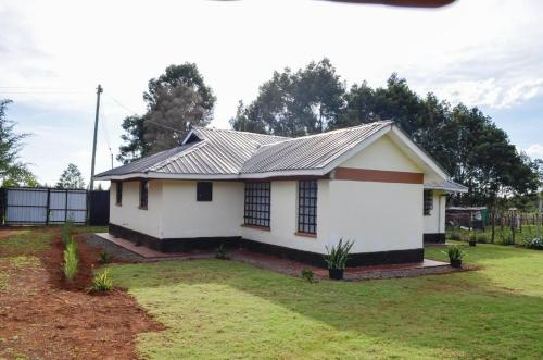 a small white house with a metal roof at ELDORET STAYS in Eldoret