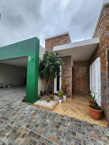 a house with a green wall and a courtyard at Seguridad con buen ambiente in Concepción de La Vega