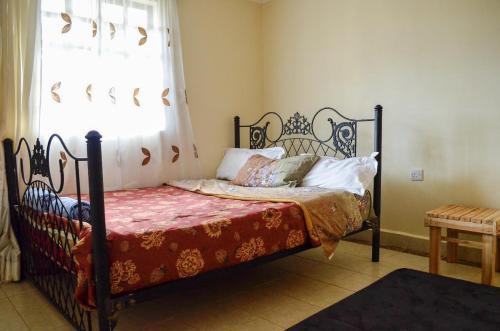 a bedroom with a bed with a wrought iron frame at ELDORET STAYS in Eldoret