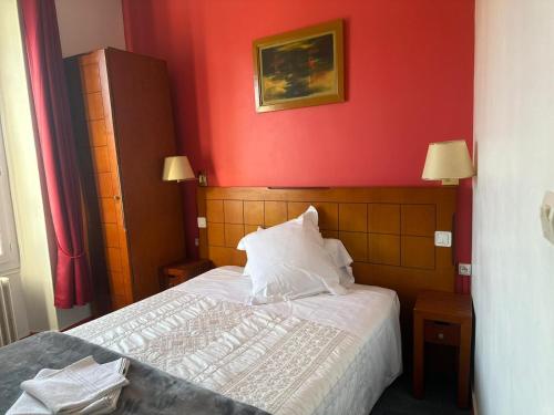 a bedroom with red walls and a bed with white pillows at LE MEDITERRANEEN Montargis in Montargis