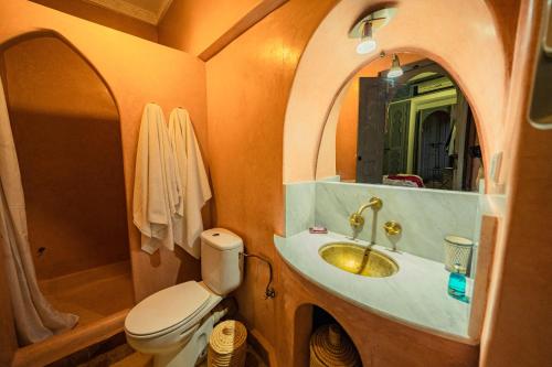 a bathroom with a toilet and a sink with a mirror at Riad Azawan in Marrakech