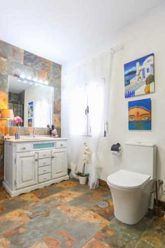 a bathroom with a toilet and a sink and a mirror at Let´s go to Valhalla in Chiclana de la Frontera