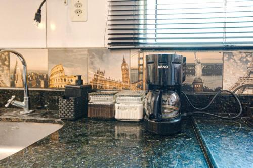 eine Kaffeemaschine auf einer Theke in einer Küche in der Unterkunft Confortavel espaçoso Lof para familia in Joinville