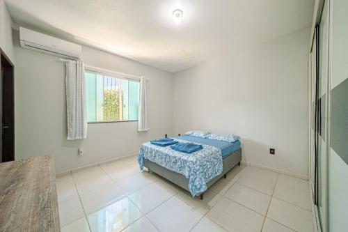 ein Schlafzimmer mit einem Bett in einem weißen Zimmer in der Unterkunft Confortavel espaçoso Lof para familia in Joinville